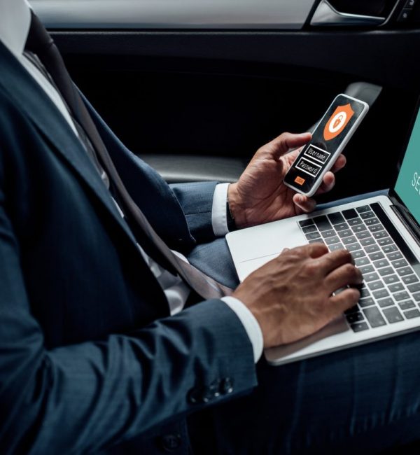 cropped-view-of-african-american-businessman-using-laptop-and-smartphone-in-car-with-cyber-security